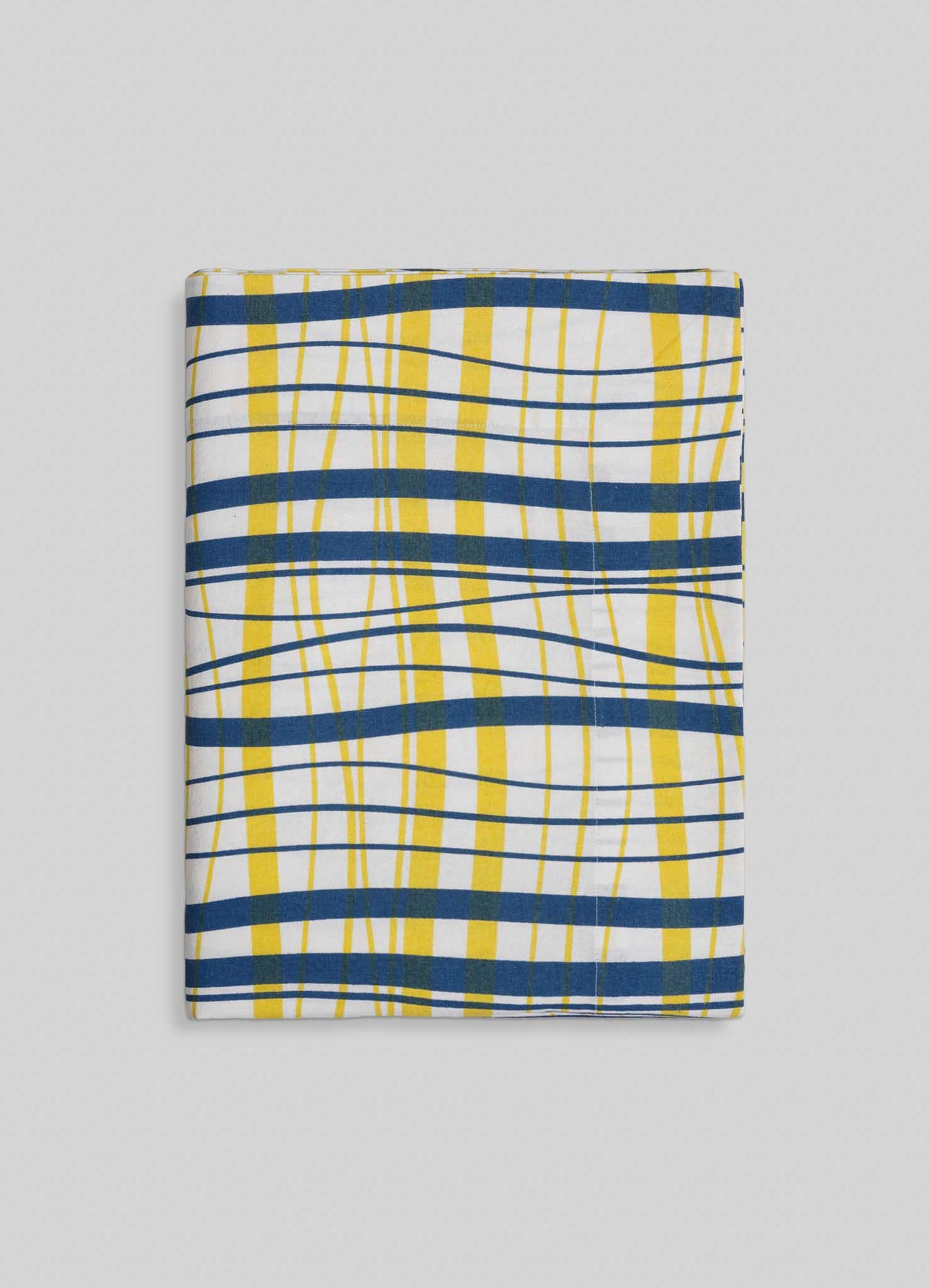 The Viya Madras Check Blue & Yellow Table Cloth features bold blue, yellow, and white checks with wavy lines on a light gray dotted background—an ideal choice for adding contemporary flair to classic Indian subcontinent designs.