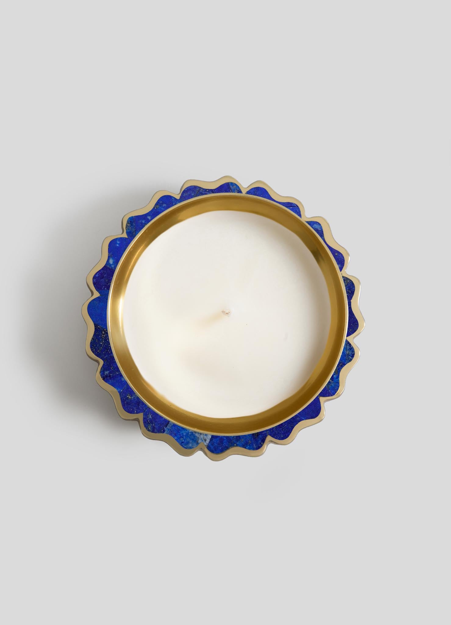 The Mystical Marigold Blue Scented Candle Diya Large by Viya is a round white candle in a blue and gold scalloped metal container, crafted with ancient techniques, shown from above on a light gray background.