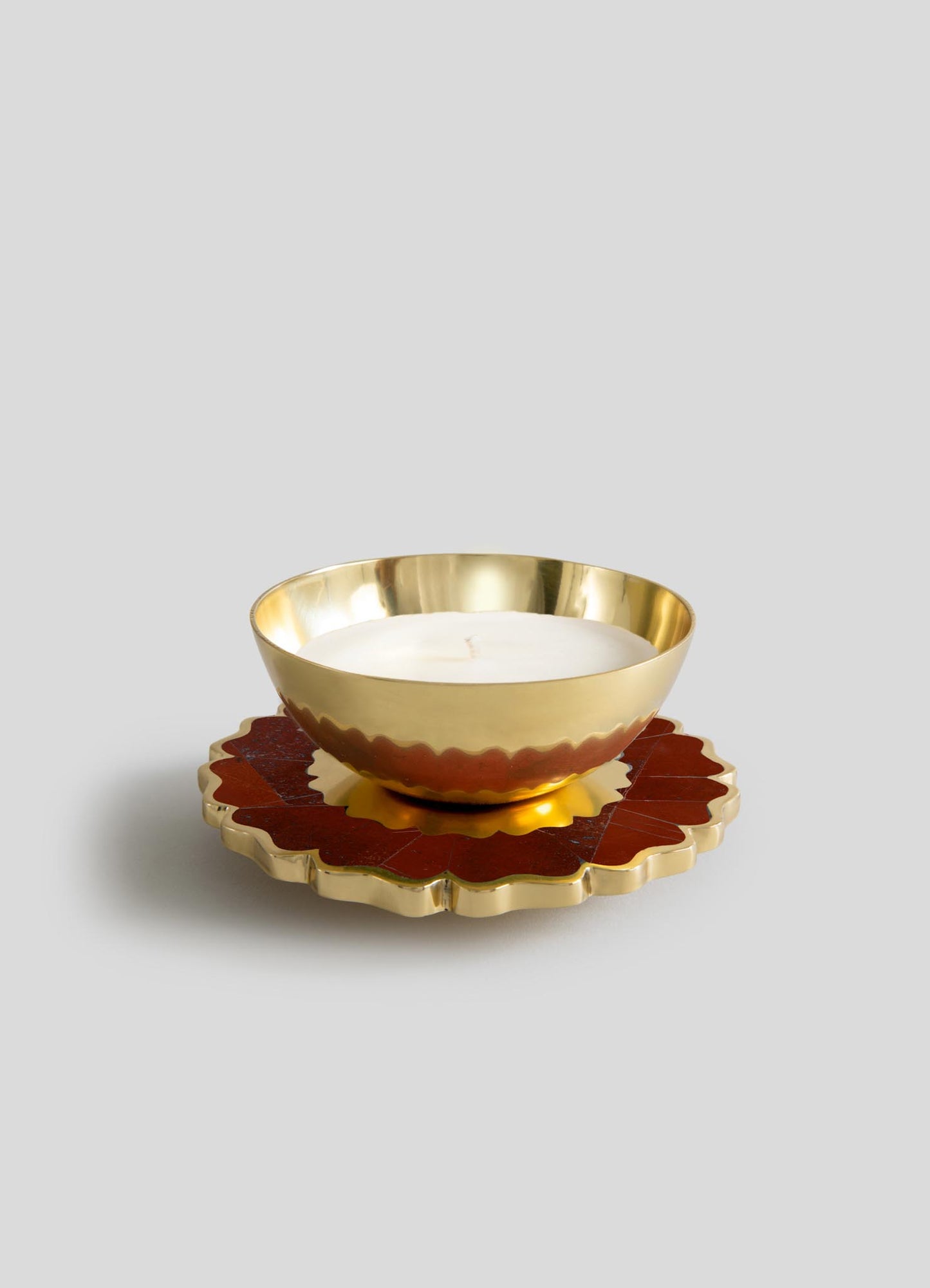 The Viya Mystical Marigold Red - Scented Candle Diya Large features a gold metal bowl candle on a scalloped gold and red base, inspired by ancient metalworking, displayed against a plain light gray background.