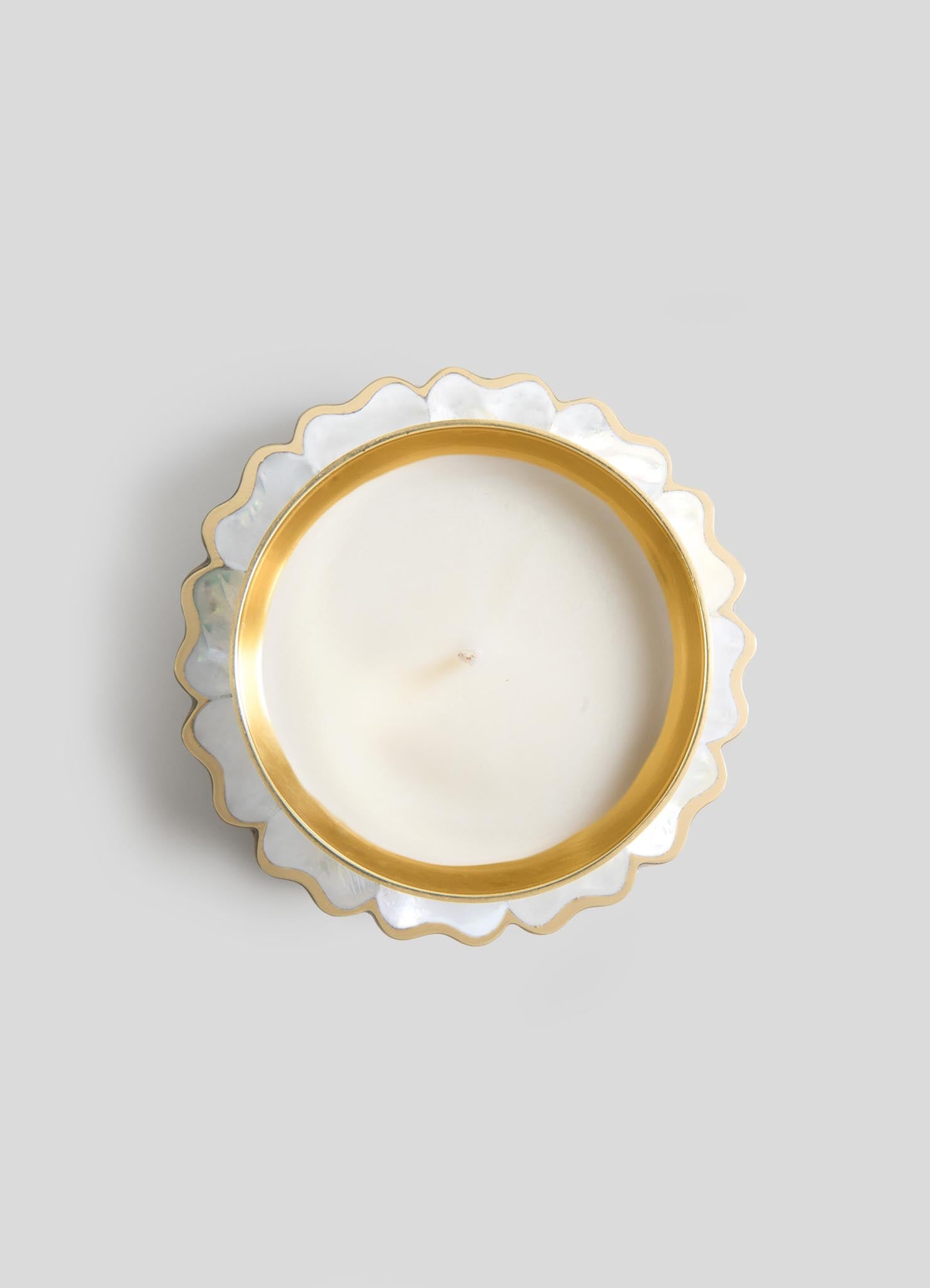 The Viya Mystical Marigold White - Scented Candle Diya Large features a single wick in a round container with a gold rim and scalloped, mother-of-pearl-style edges, viewed from above on a light gray background.