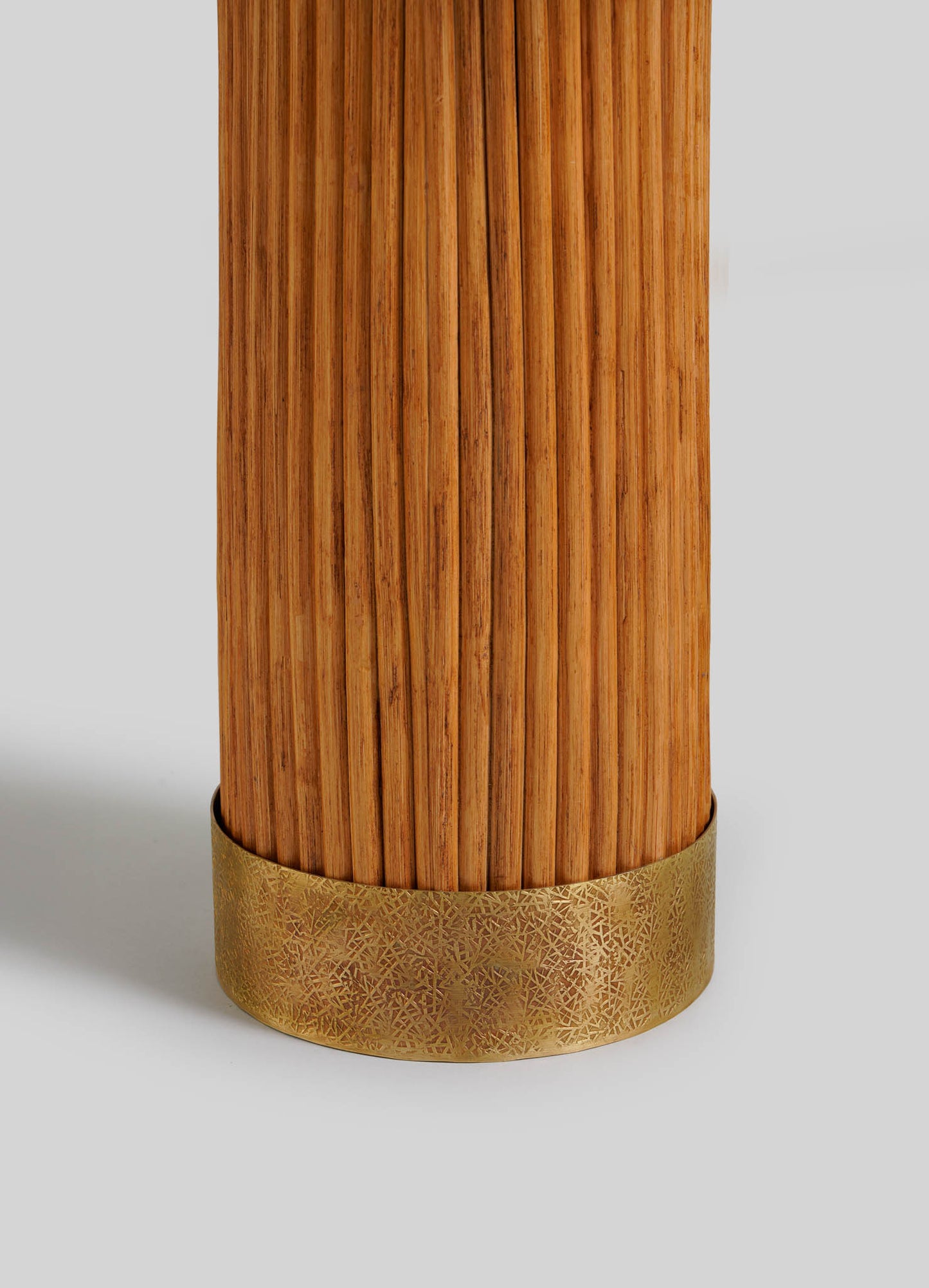 A close-up of the VIYA Namsai Table Lamp Round, a cylindrical wooden lamp with vertical grooves and a decorative gold-toned embossed band at the base, set against a plain light gray background.