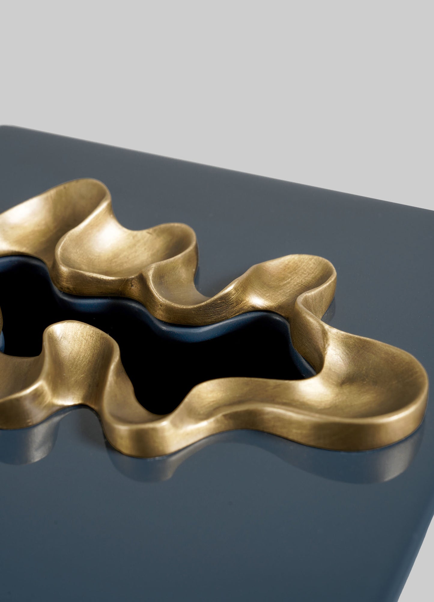 The VIYA Saffron Dark Blue Tissue Box Small features a wavy, gold-toned accent set in glossy dark blue, reminiscent of saffron threads, and is displayed against a simple light gray background.