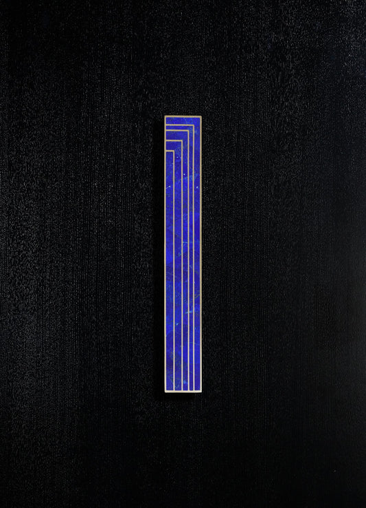 A vertical blue geometric inlay with gold trim set against a textured black background.