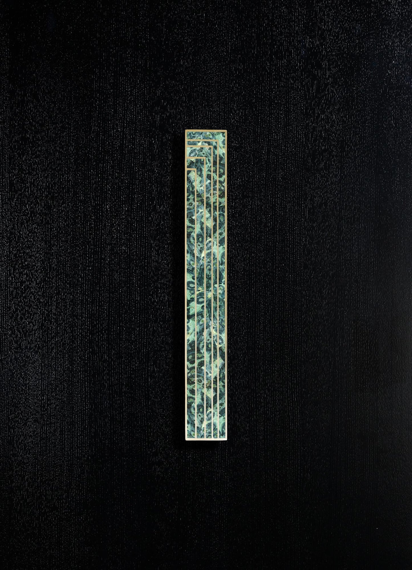 A tall, narrow decorative panel with a metallic frame and a patterned surface featuring abstract floral motifs in shades of green and blue, mounted on a textured black background.