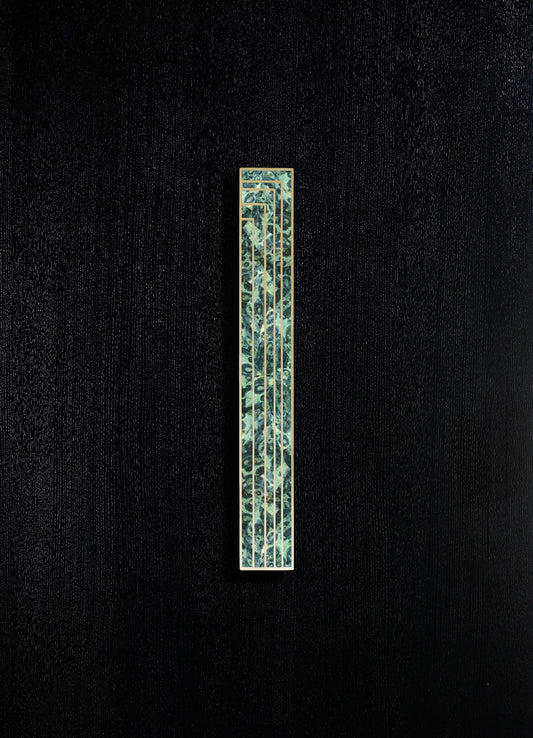 A tall, narrow decorative panel with a metallic frame and a patterned surface featuring abstract floral motifs in shades of green and blue, mounted on a textured black background.