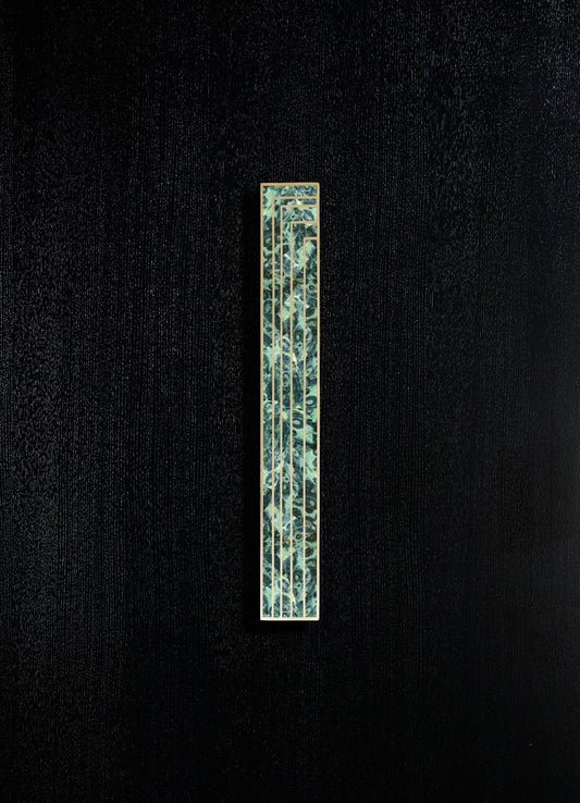A rectangular wall-mounted sculpture with a brass frame and a patterned inlay featuring marine-inspired motifs in shades of blue and green. The piece has a contemporary style, set against a textured black background.
