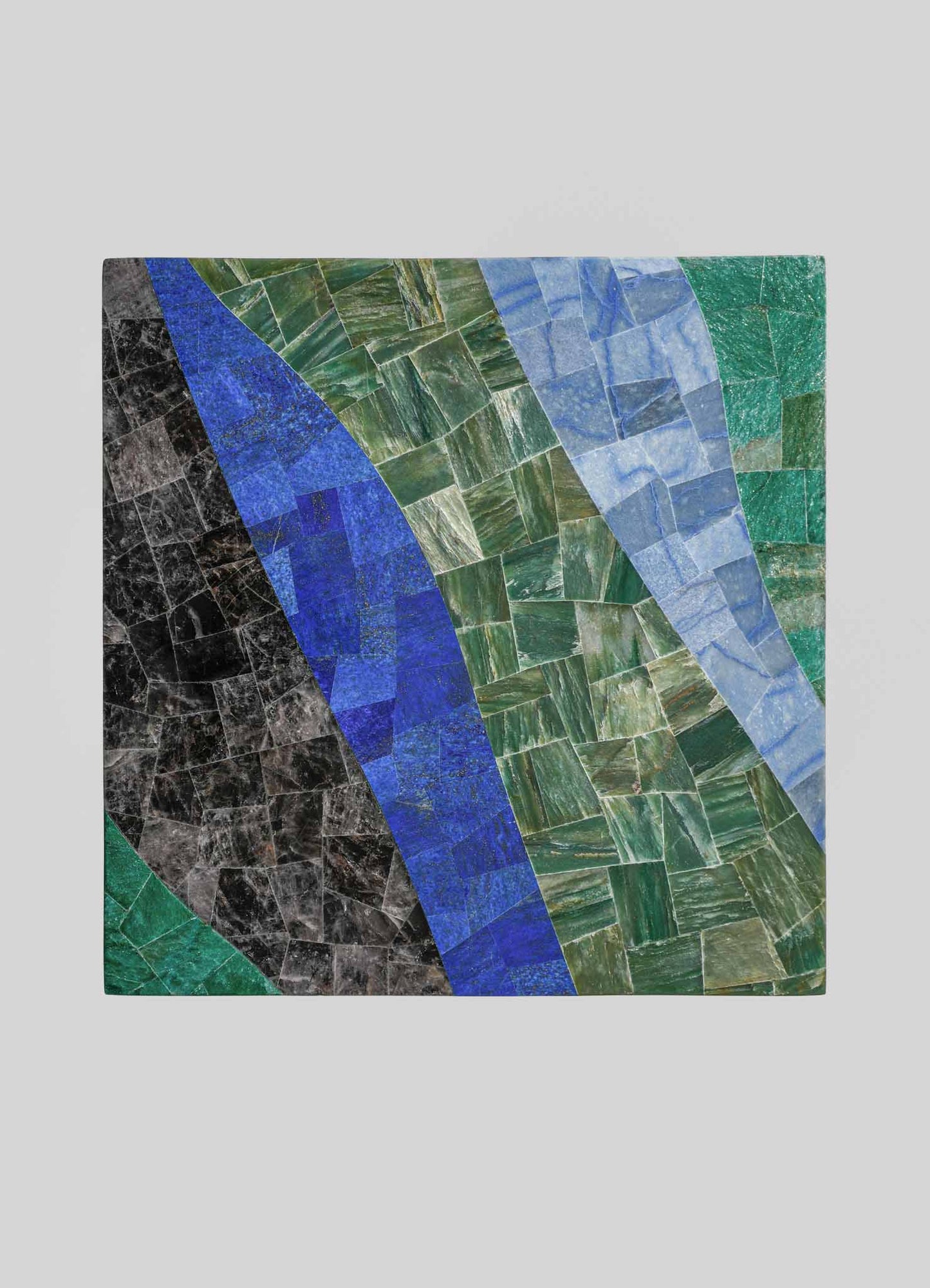 A rectangular inlay mosaic tabletop featuring geometric patterns in shades of green, blue, black, and gray, composed of polished stone tiles with a glossy finish.