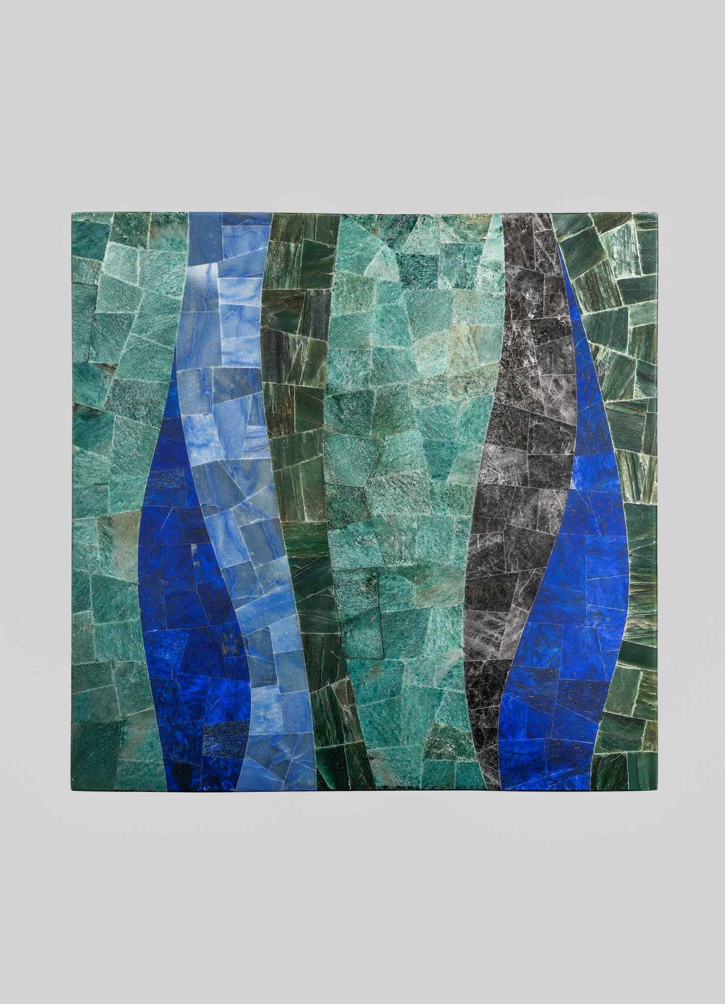 Mosaic art piece made of irregularly shaped tiles in shades of green, blue, black, and gray, with a flowing, abstract pattern. The mosaic features a contemporary style with bold color contrasts and textured surfaces.