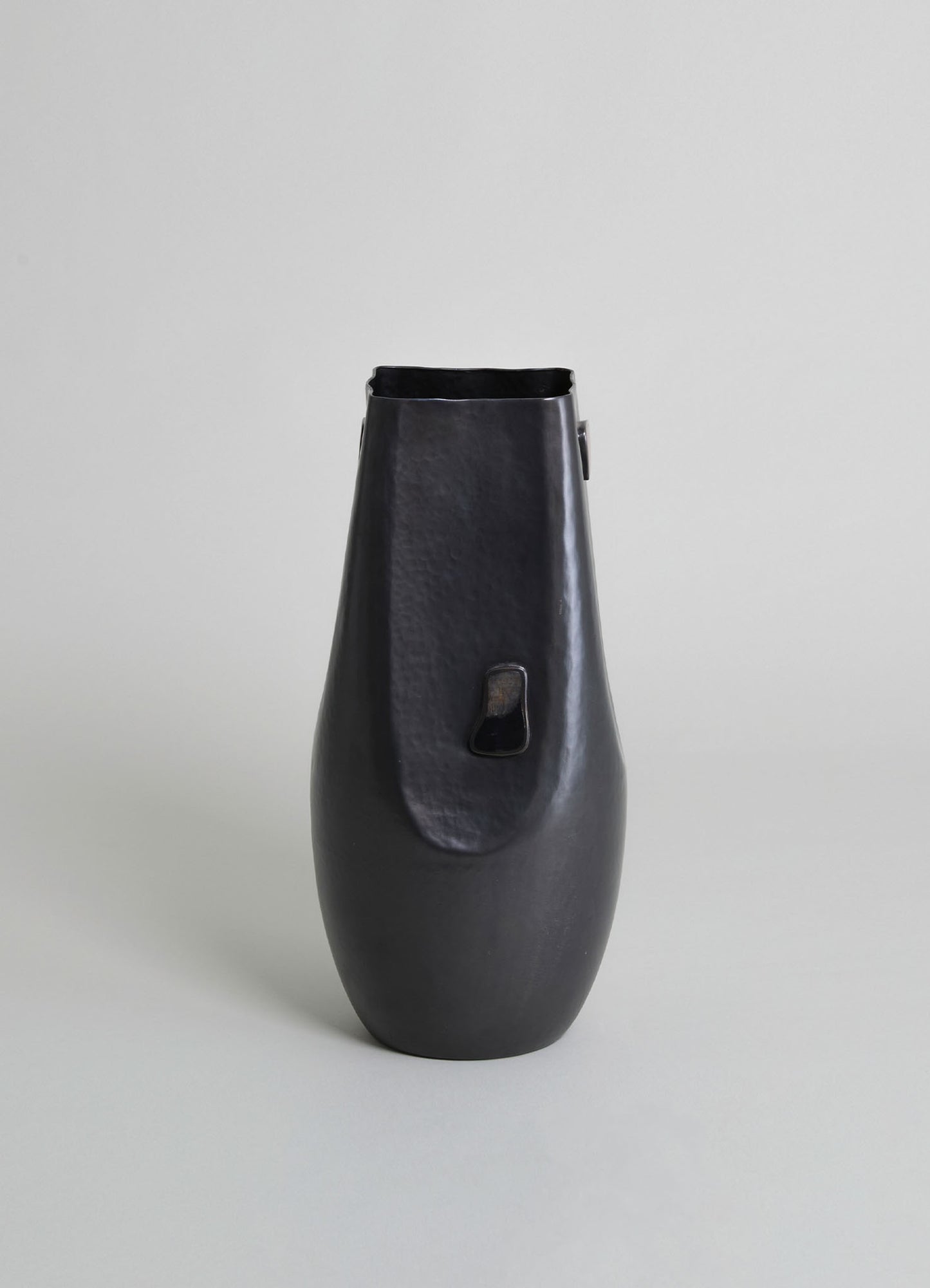 Black matte ceramic vase with a textured surface and a small rectangular opening, featuring a minimalist and contemporary style.