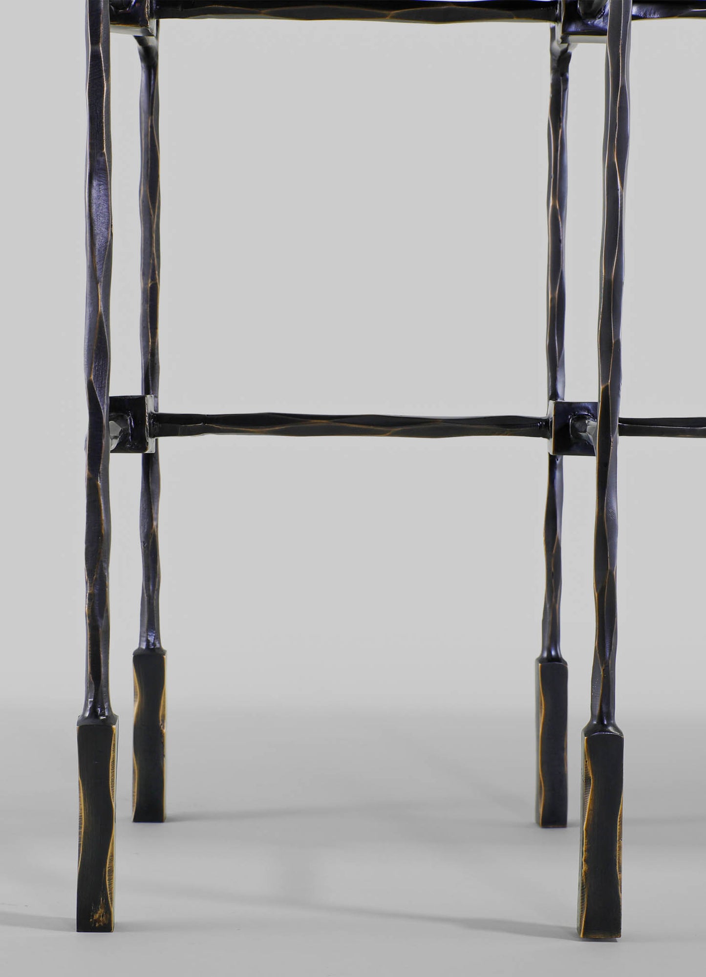 Metal table with a black finish and a twisted, textured design on the legs, featuring a simple rectangular frame on a light gray background.