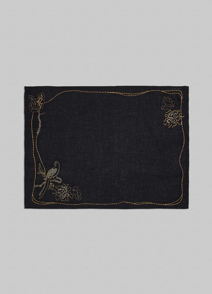 Black fabric square with gold embroidery on a gray background viya placemats