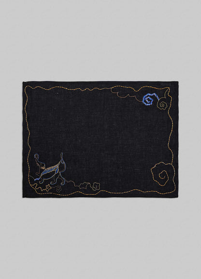 Embroidered black fabric patch with decorative elements on a gray background viya placemats