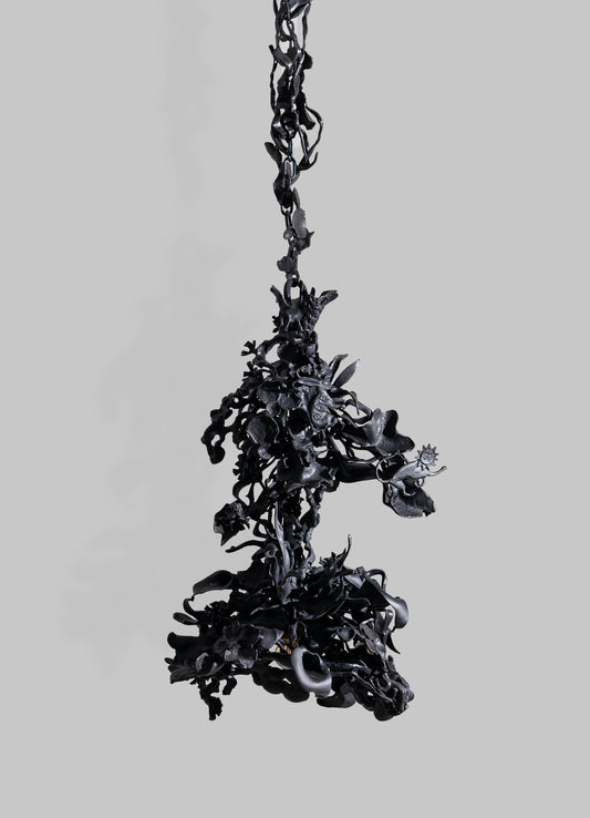 The Gardens Of India Pendant Light by VIYA features dark, abstract forms suspended against a gray backdrop, with twisted shapes inspired by tangled vines and rich Indian cultural symbolism.