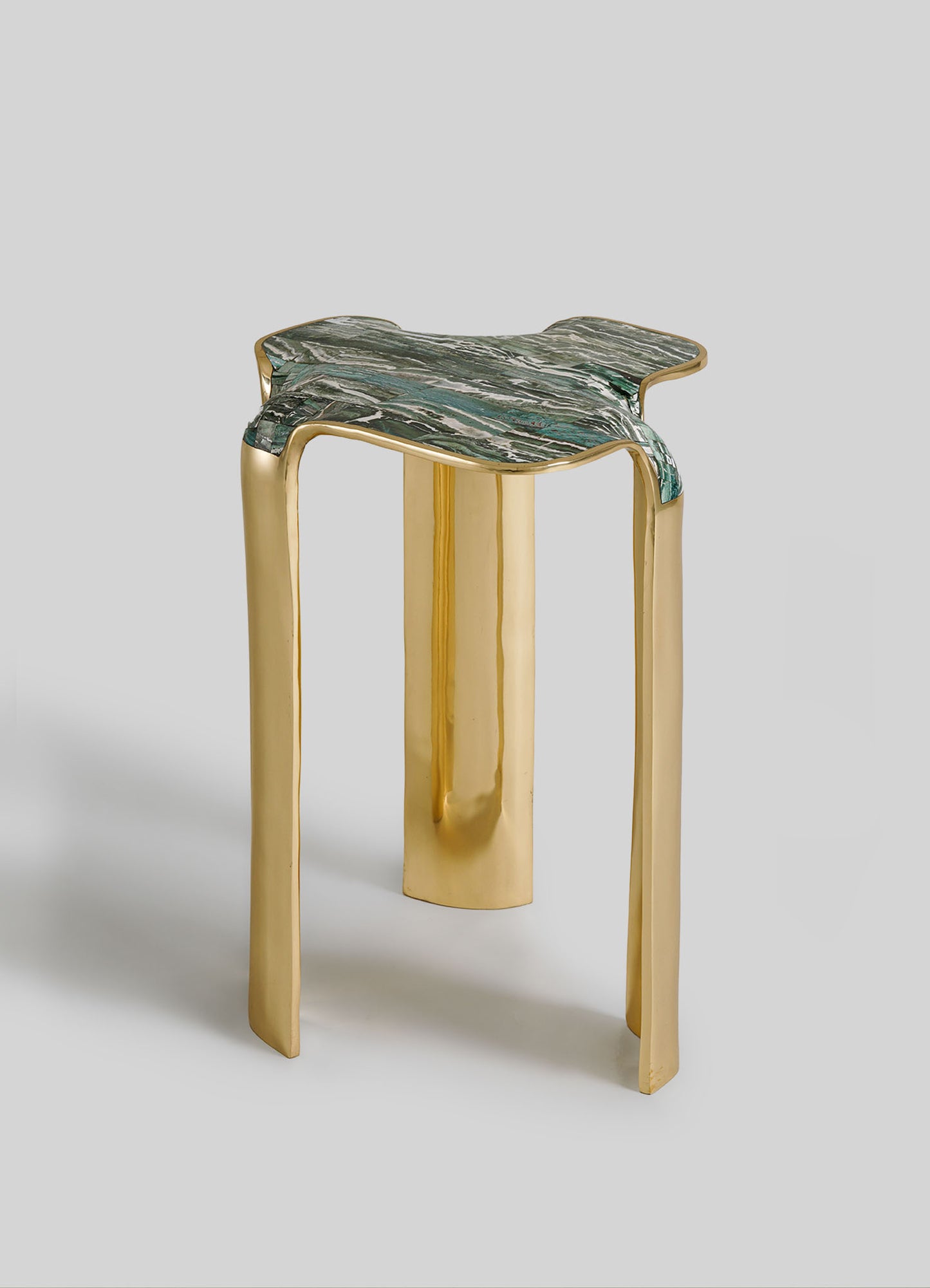 Stool with gold legs and green marble top on a light gray background
