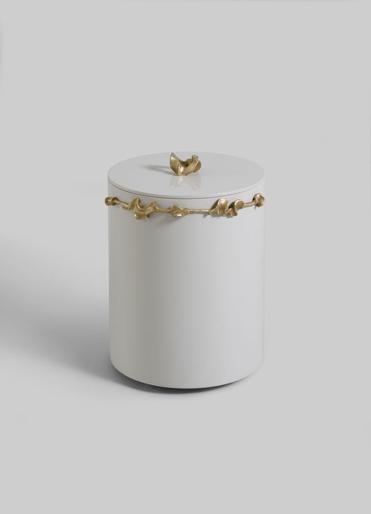 The VIYA Saffron Ecru Bin With Lid is a modern, cylindrical white container, featuring an irregular gold band and handle, set against a plain light gray background.