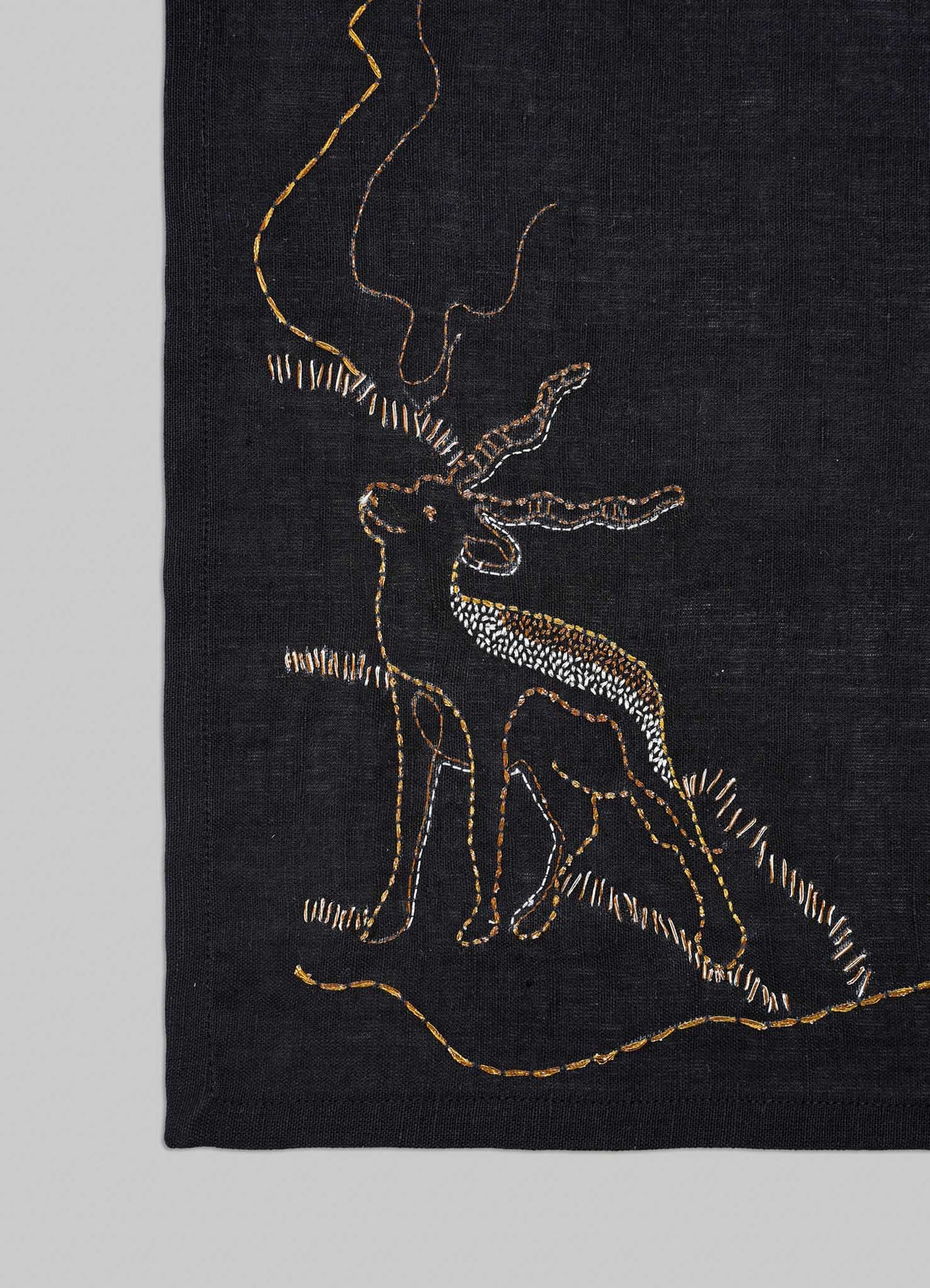 Embroidered design of a deer on a black fabric background placemats viya