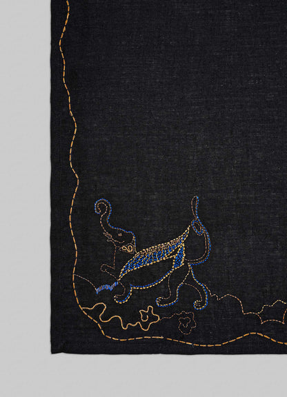 Embroidered design on a black fabric with blue and gold elements viya placemats