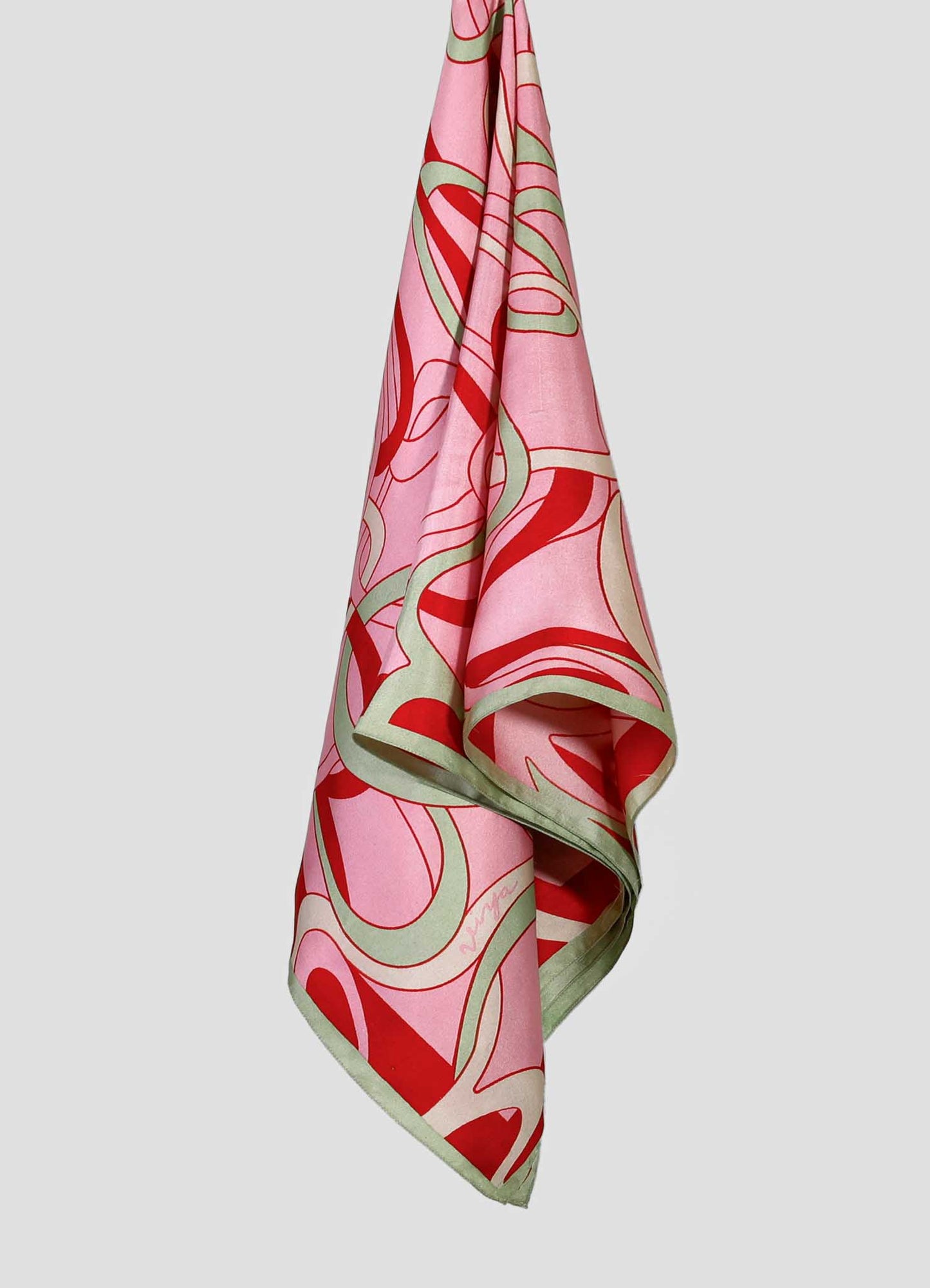 A silk scarf featuring a bold, abstract floral pattern in shades of pink, red, and green, with a soft sheen and finished edges, displayed against a neutral background.