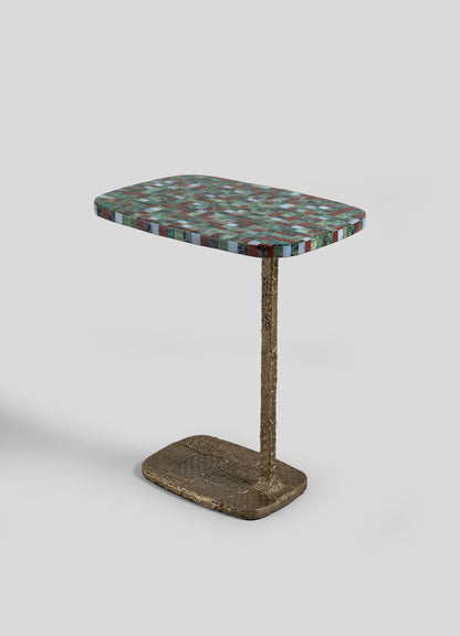 The VIYA Mosaic Red Side Table features a rectangular, multicolored mosaic stone tabletop set atop a single textured, golden metal leg attached to a matching rectangular cast brass base.