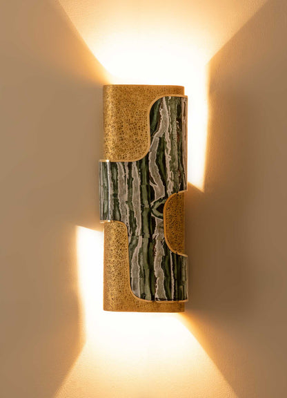 Wall-mounted light fixture with a combination of textured gold-colored metal and green marble in a contemporary style, casting warm upward and downward illumination.
