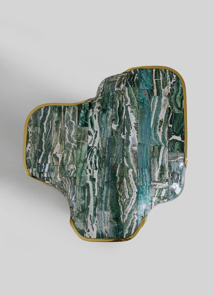 The VIYA Coonoor Side Table features an abstract, organic shape with a glossy green and white marbled top inspired by Indian landscapes, accented by a gold metallic trim along the irregular edge, set against a light gray background.
