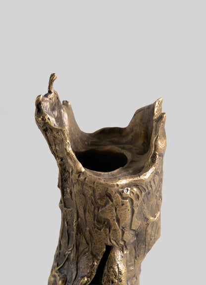 The VIYA Kikar Candle Holder Large features a sculpted bronze design with an irregular, bark-like textured surface and an uneven open top, inspired by metalworking traditions, shown against a plain light gray background.