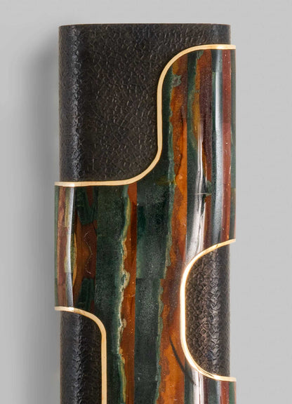 A sculptural table lamp with a textured black surface combined with colorful onyx or marble inlays, featuring gold-toned metallic accents outlining its organic, curvilinear shape.