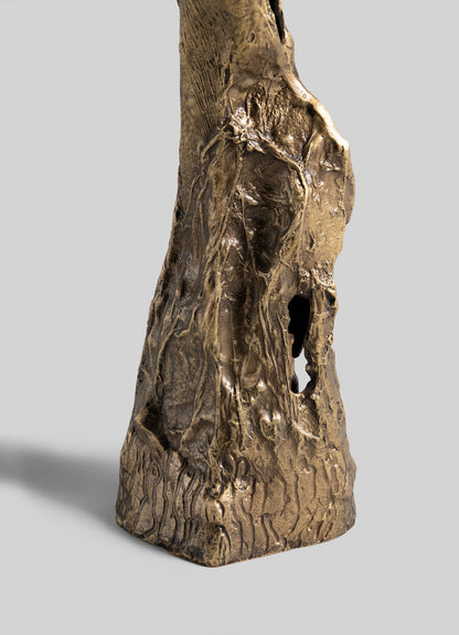 A close-up of the VIYA Kikar Candle Holder Large shows its textured bronze surface with intricate, tree-like patterns and organic details, highlighting expert metalwork, set against a plain gray background.