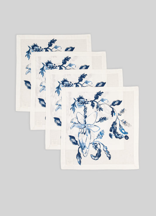 Set of four white napkins with blue floral patterns on a gray background