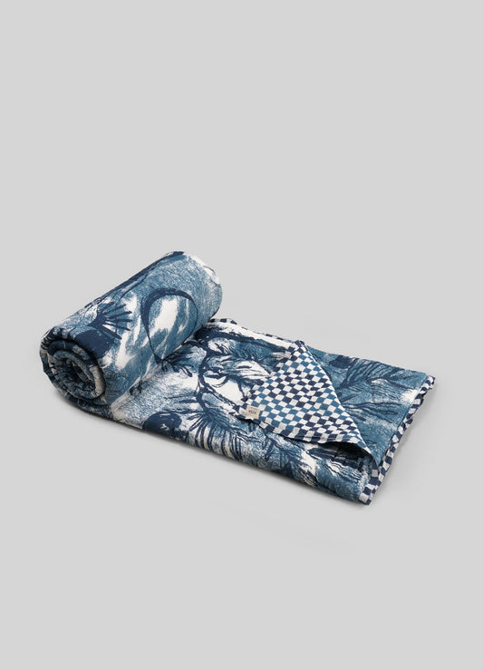Rolled-up quilt with blue floral and checkered patterns viya