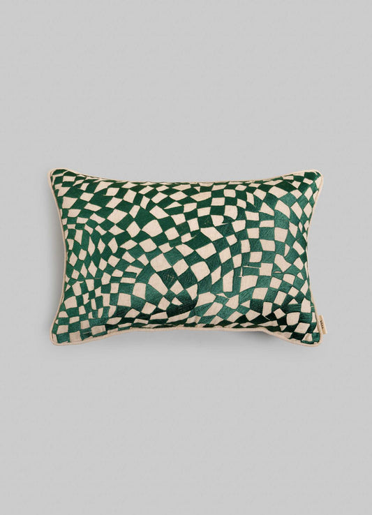 The Viya Dreamscape Green Embroidered Checks Cushion Cover (12"x18") features a green and white geometric wavy checkerboard design inspired by embroidered textiles, set on a plain light gray background.