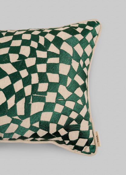 The Viya Dreamscape Green Embroidered Checks Cushion Cover (12"x18") features a green and cream abstract wavy checkered pattern inspired by embroidered textiles, shown on a plain light gray background with a small fabric tag on one edge.