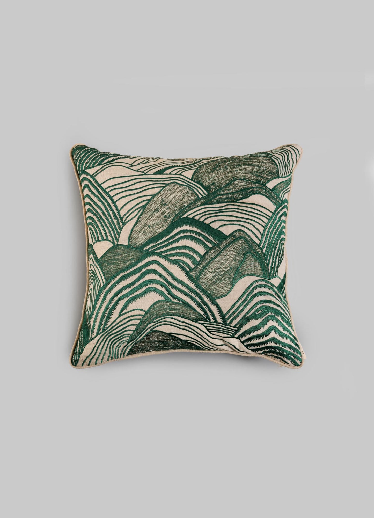 The Viya Dreamscape Green Embroidered Mounds Cushion Cover (18"x18") features a textured, abstract green and cream design reminiscent of Rajput manuscript art, set against a plain light gray background.