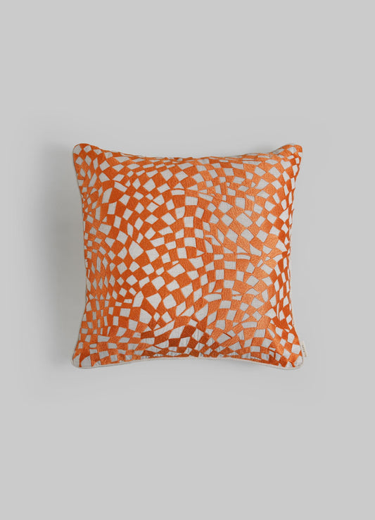 The Viya Dreamscape Orange Embroidered Checks Cushion Cover (18"x18") features a vibrant orange and white geometric pattern on light grey, inspired by traditional embroidered textiles and symbolic motifs.