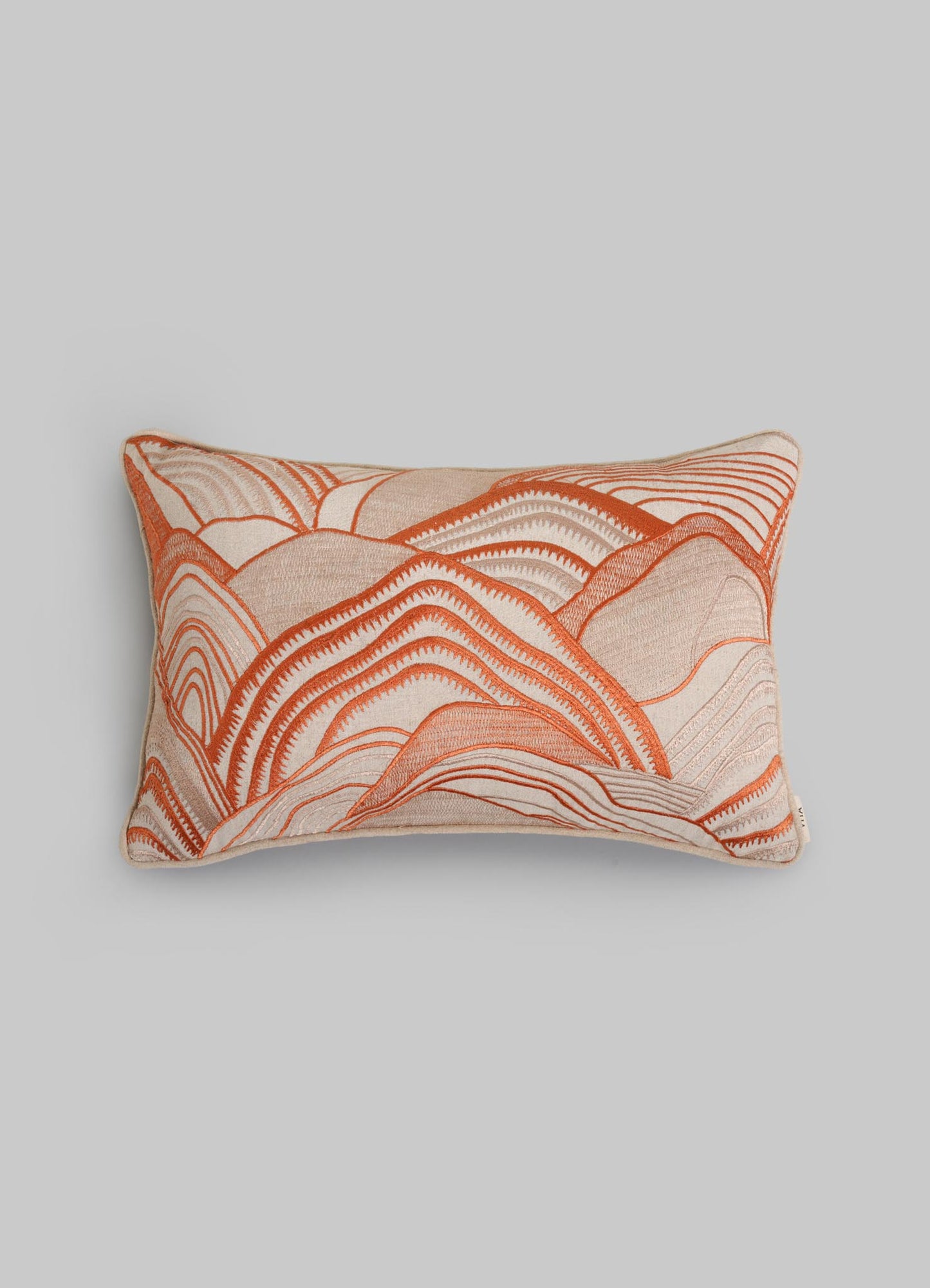 The Viya Dreamscape Orange Embroidered Mounds Cushion Cover (12"x18") features textured, wave-like embroidery in orange, rust, and cream on a light background, shown against a plain gray backdrop.