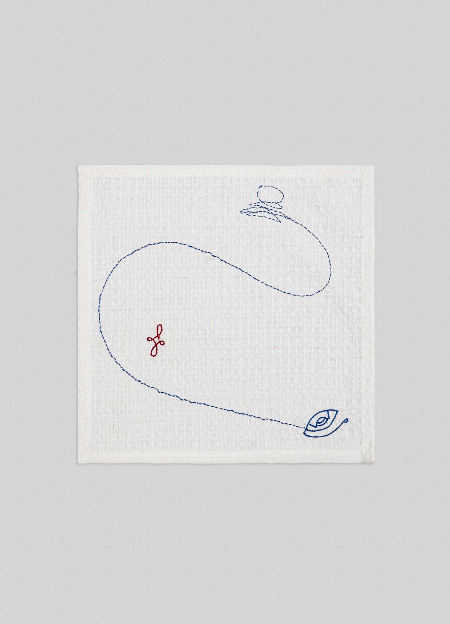 The Viya Evil Eye Hand Embroidered Ecru Face Towels (Set of 4) features white textured cloth with blue spinning top and Nazar motifs, plus a small red embroidered symbol on a light gray background.