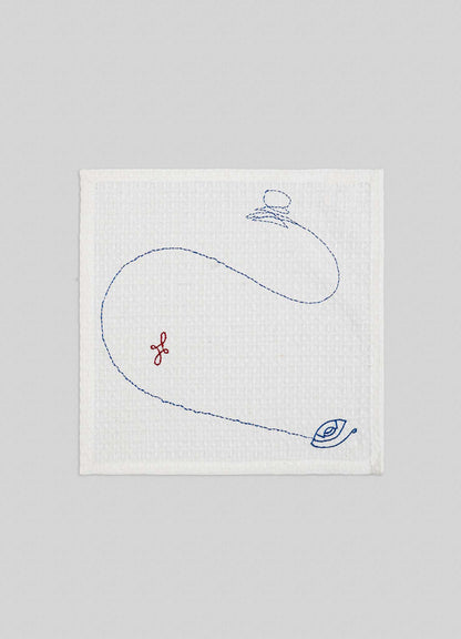 The Viya Evil Eye Hand Embroidered Ecru Face Towels (Set of 4) features white textured cloth with blue spinning top and Nazar motifs, plus a small red embroidered symbol on a light gray background.