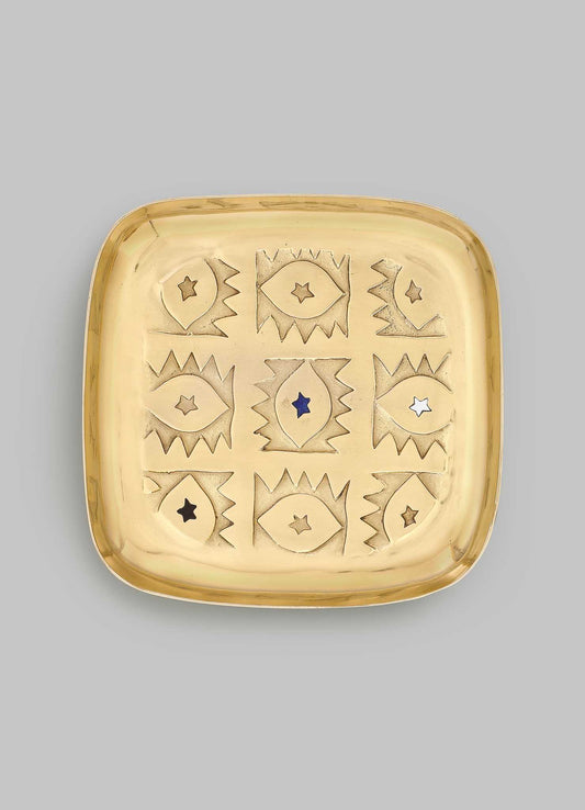 The VIYA Evil Eye Trinket Tray Large is a square brass tray with rounded corners, engraved with nine abstract evil eyes—each with a star center—in a 3x3 grid, symbolizing protection and elegance.