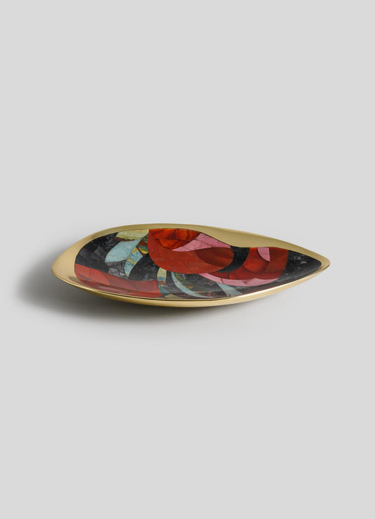 The VIYA Gardens Of India Bowl Small is a shallow, oval dish with a shiny gold rim and base, featuring an abstract red, green, and black mosaic inspired by Indian Garden motifs on a plain light grey background.