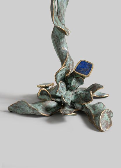 The Glory Lily Multicolour Side Table Large by VIYA features a sculptural cast brass base with abstract, wavy gold-edged leaves, a greenish patina, and a blue stone accent inspired by the Glory Lily.