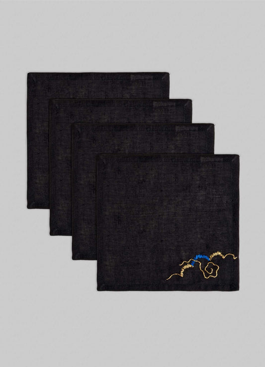 The Viya Gajasimha Hand Embroidered Black & Gold Cocktail Napkins (Set of 4) are neatly stacked, each featuring a gold embroidery inspired by ancient Indian art, set against a light gray background.