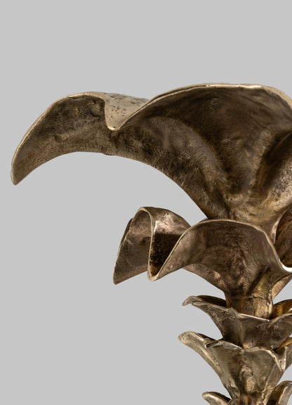 The VIYA Indian Vessel Finial features a golden-bronze metallic design inspired by brass vessels and Indian home decor, resembling overlapping curved leaves or petals, shown against a plain gray background.