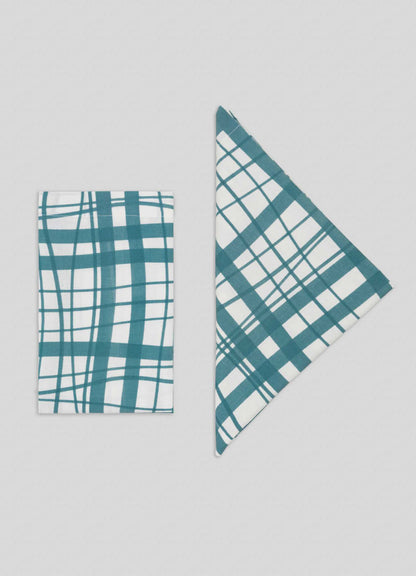 Viya's Madras Check Aqua Napkins - Set of 4 feature teal and white checks, displayed on a light background with one neatly folded into a rectangle and the other into a triangle, offering contemporary style inspired by the Indian subcontinent.