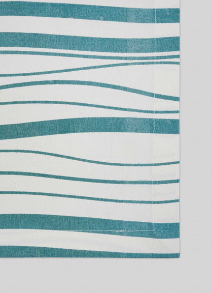 Viya's Madras Check Aqua Placemats – Set of 4 – feature uneven horizontal teal stripes on white, blending contemporary design with Indian textile heritage. Only part of a placemat is shown against a light gray background.
