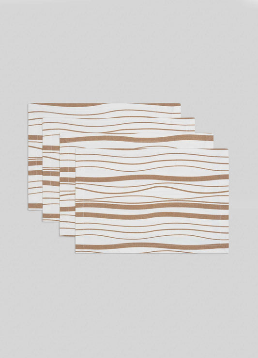 The Viya Madras Check Beige Placemats, set of 4, feature a white base with wavy brown lines inspired by contemporary Indian textiles, shown stacked in a staggered arrangement on a light gray surface.