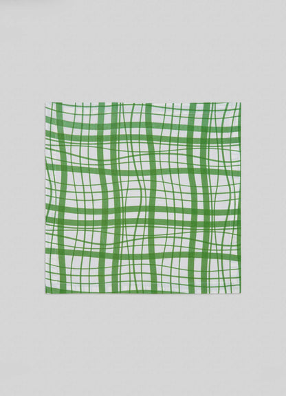 The Viya Madras Check Green Napkins - Set of 4 feature a square white fabric with a modern wavy green plaid inspired by Indian Madras checks and intersecting lines in varying thicknesses.