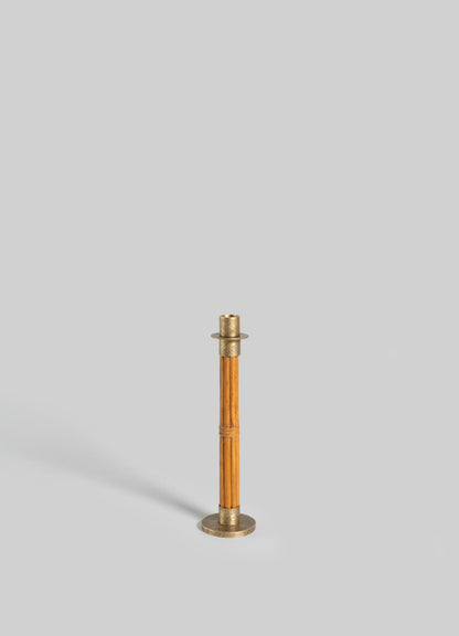 The VIYA Namsai Candle Holder Medium, featuring elegant brass and wood design, stands upright on a light gray background and casts a faint shadow to the left.