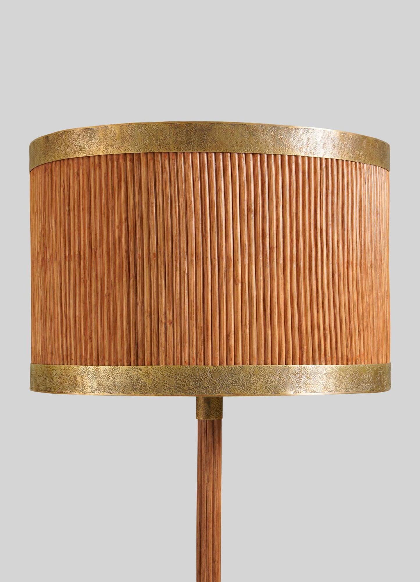 A close-up of the VIYA Namsai Floor Lamp Round, showcasing its cylindrical wooden shade with vertical grooves and brass accents on the top and bottom, set against a plain light gray background.