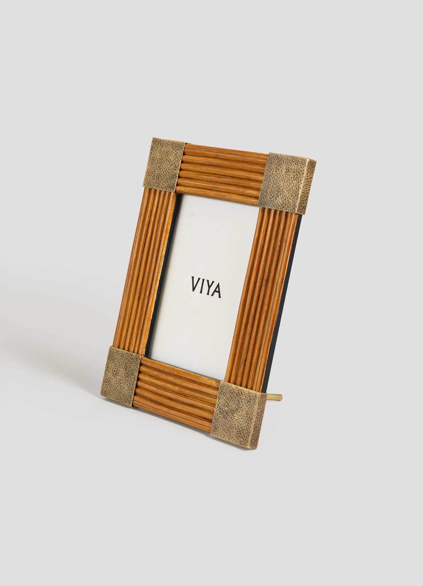 The VIYA Namsai Photo Frame Large features a ribbed wooden texture, cane weaving, and snakeskin-patterned corners, standing upright on a pale gray surface with "VIYA" displayed inside.