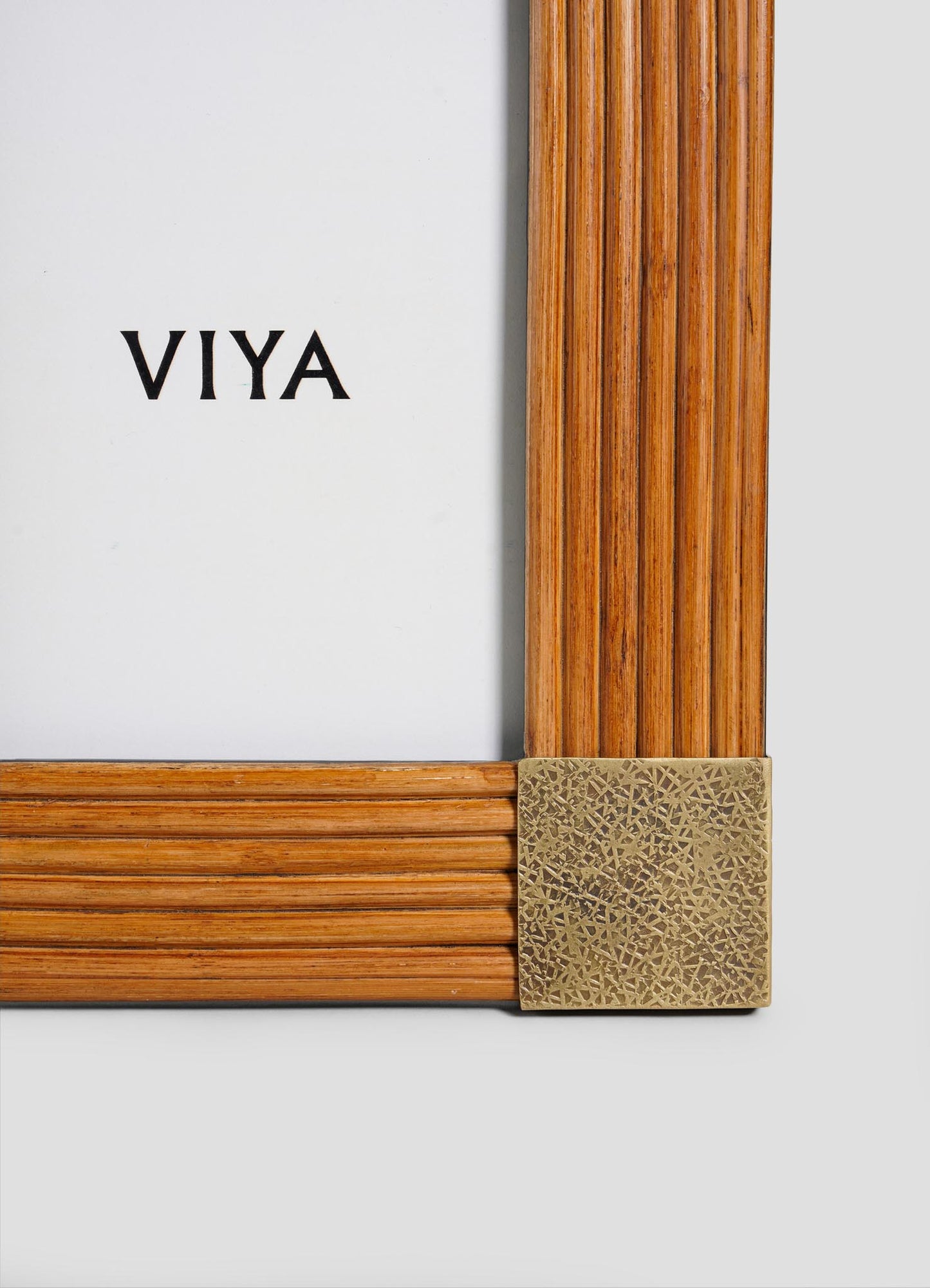 The VIYA Namsai Photo Frame Large features vertical and horizontal grooves, a decorative brass corner, and "VIYA" centered on a white background, inspired by handcrafted frames from the Namsai collection.
